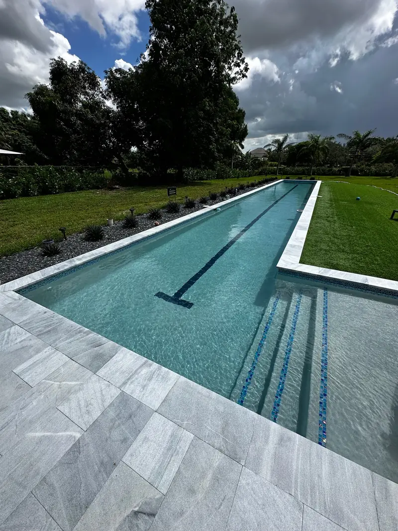 Lap pool entry steps with blue tile lines and light gray pavers