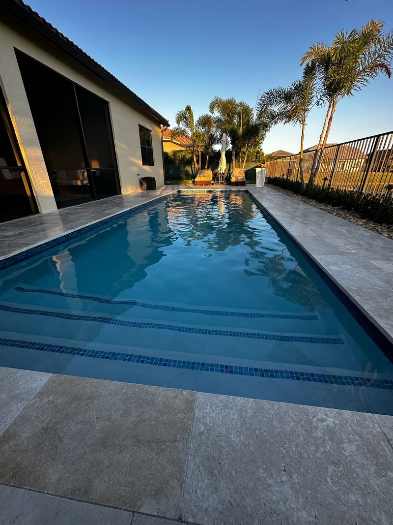 Pool entry steps with tile lines and stone-style pavers in warm evening light